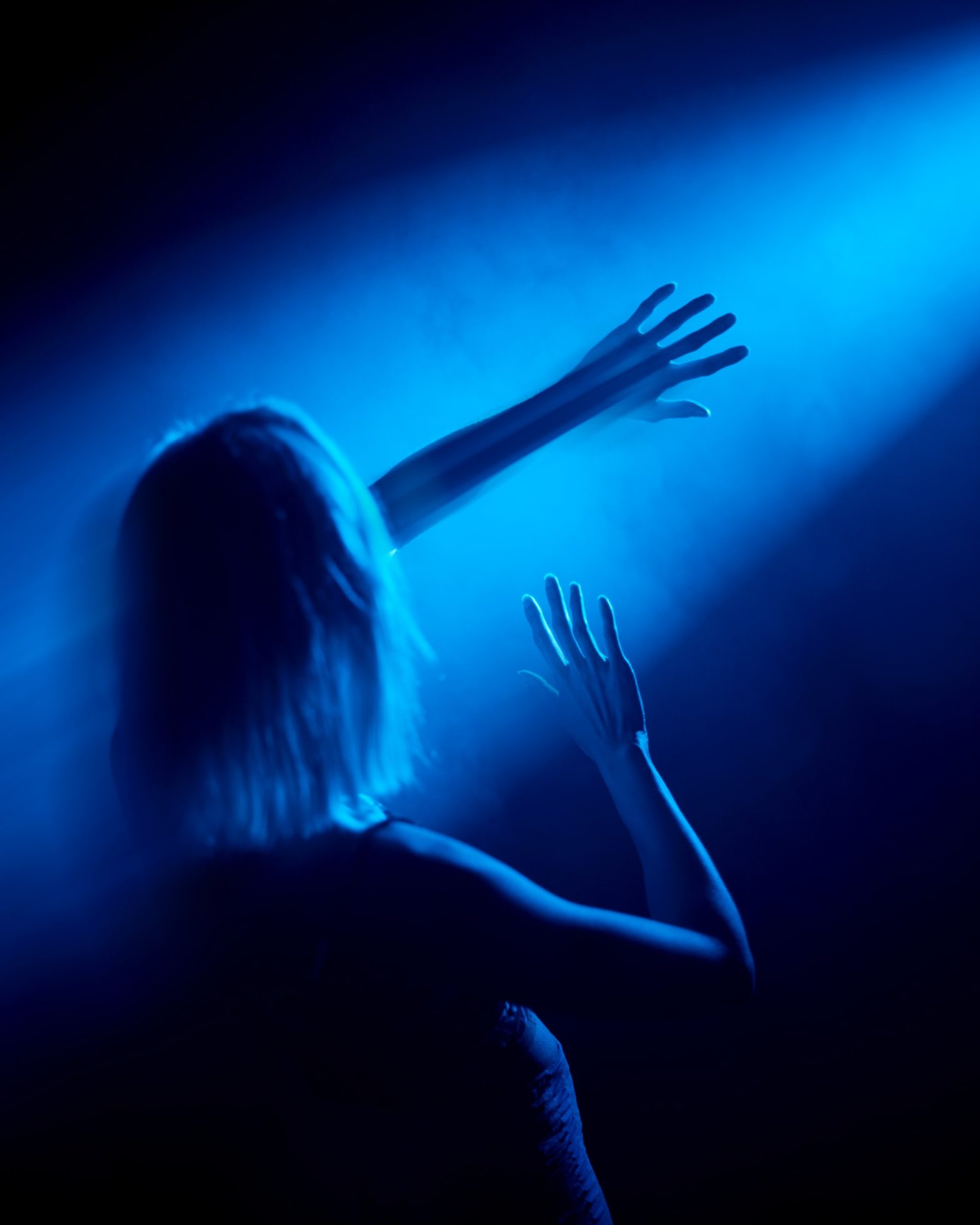 Blue Light shining on a woman who blocks the light