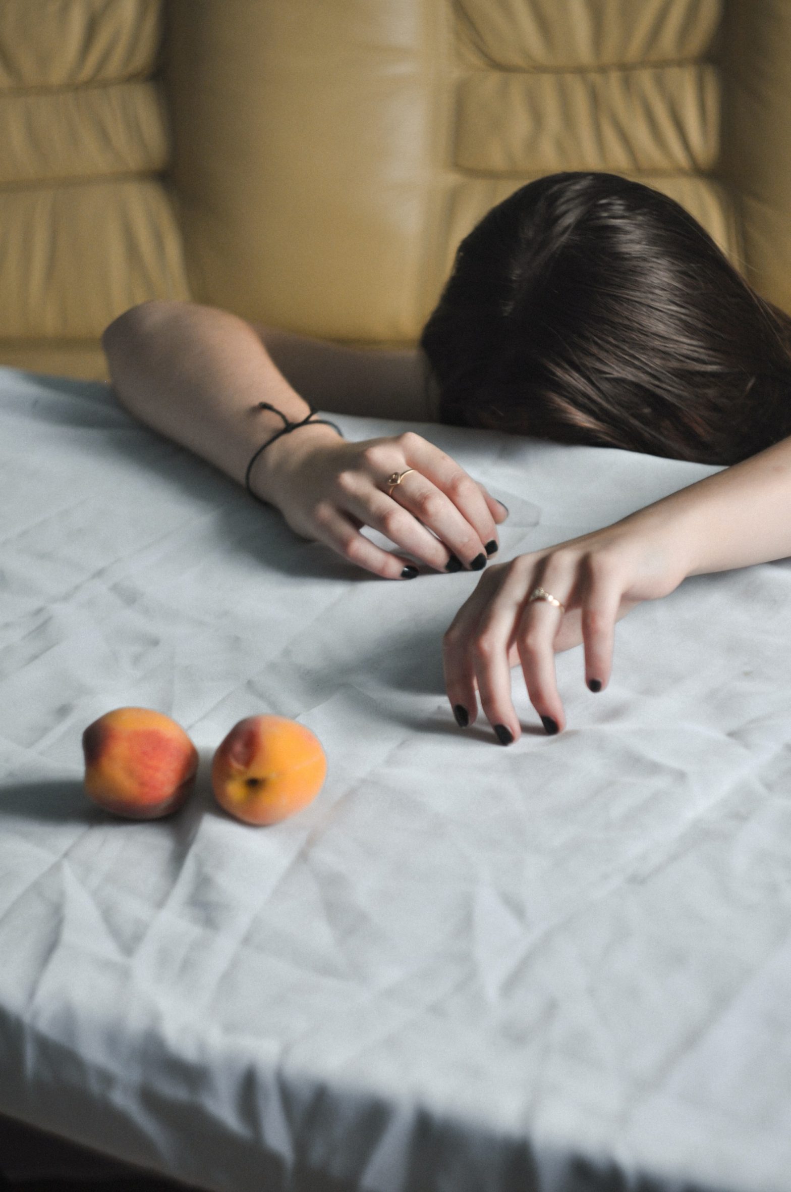 woman at a table head down hands resting